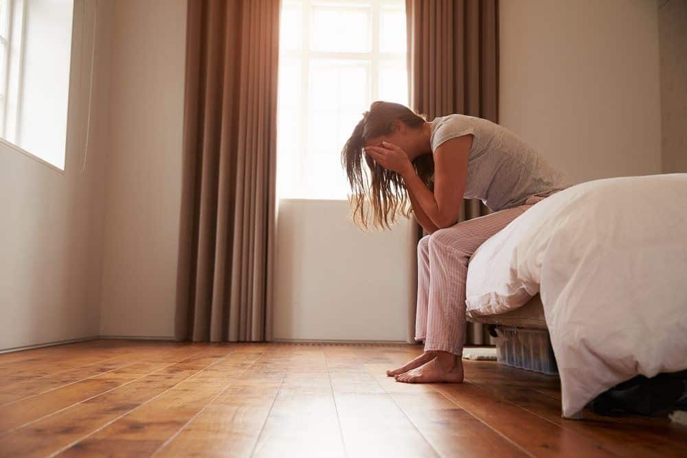 Erfahrungen - Ich dachte ich kann vergessen Weinende Frau sitzt auf dem Bettende und hat die Hände vor dem Gesicht
